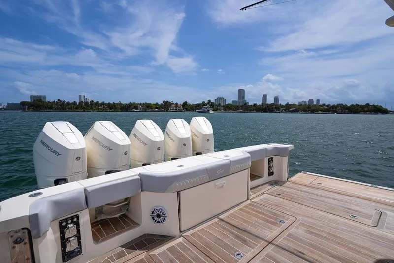 Slide: The Image of 2020 Scout 530 LXF boat with five Mercury engines, overlooking a city skyline on the water. - 69