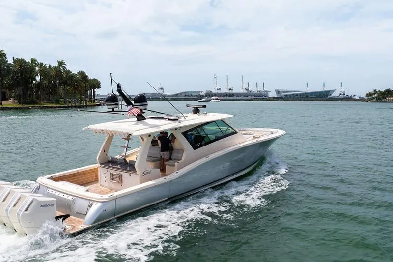 Slide: The Image of 2020 Scout 530 LXF luxury yacht cruising in scenic waters near a port. - 7