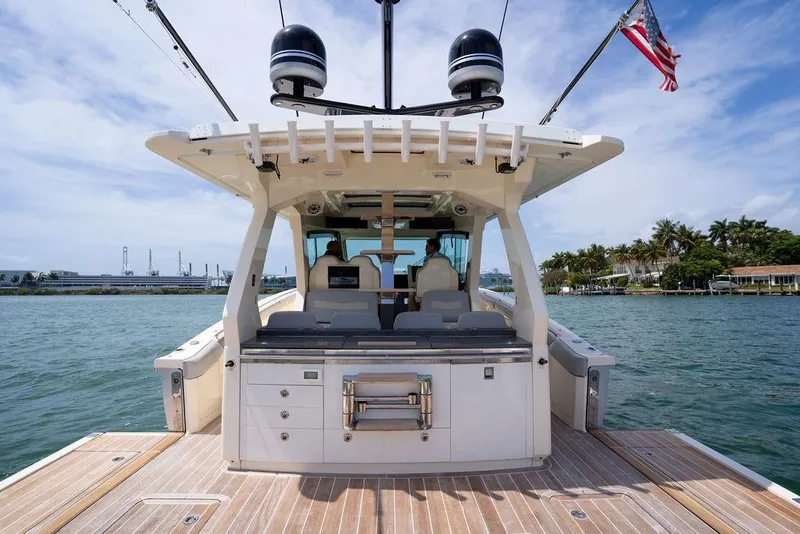 Slide: The Image of 2020 Scout 530 LXF luxury boat docked on calm waters, featuring spacious deck and modern amenities. - 87