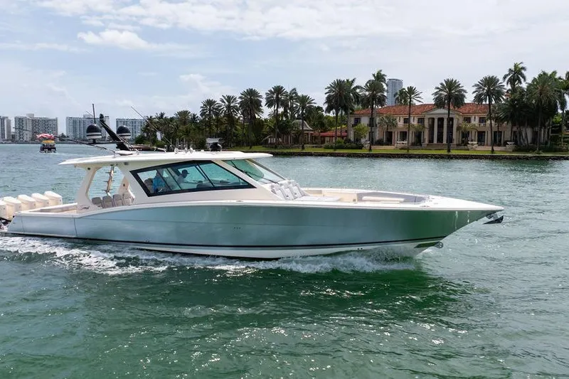Slide: The Image of 2020 Scout 530 LXF yacht cruising near luxury waterfront homes. - 9