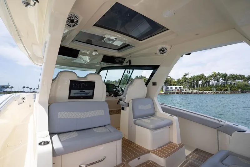 Slide: The Image of Interior view of 2020 Scout 530 LXF luxury boat with modern seating and scenic water backdrop. - 91