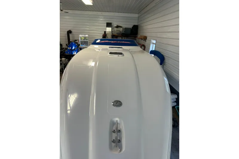 Slide: The Image of 2004 Sunsation 32 Dominator boat in a garage, showcasing sleek white hull design. - 18