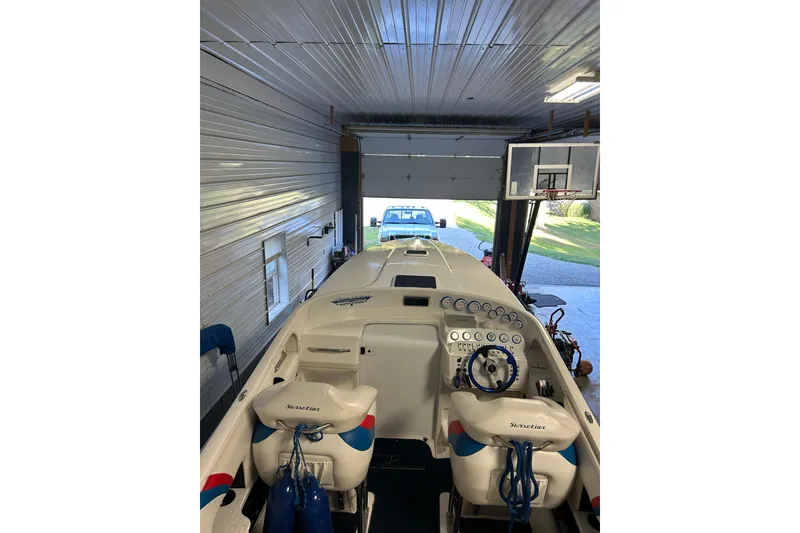 Slide: The Image of 2004 Sunsation 32 Dominator boat in garage, showcasing cockpit and controls. - 19