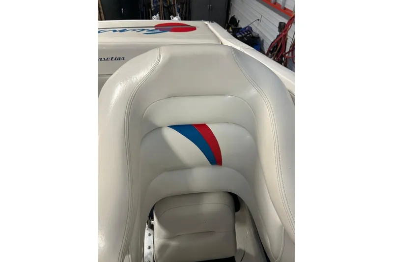 Slide: The Image of White leather seat with red and blue accents in a 2004 Sunsation 32 Dominator boat. - 22