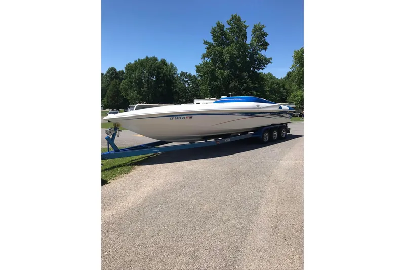 Slide: The Image of 2004 Sunsation 32 Dominator boat on trailer, parked outdoors on a sunny day. - 3