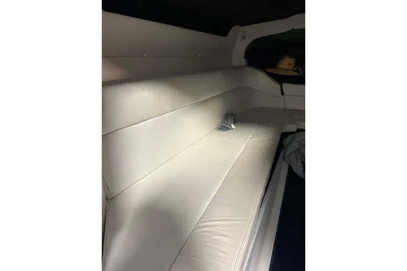 Slide: The Image of Interior seating of a 2004 Sunsation 32 Dominator boat, featuring white upholstery. - 32