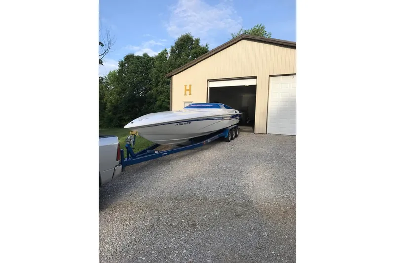 Slide: The Image of 2004 Sunsation 32 Dominator boat on trailer outside a garage. - 4
