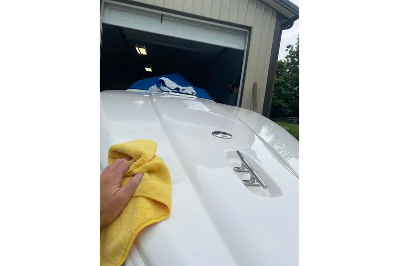 Slide: The Image of Hand polishing a 2004 Sunsation 32 Dominator boat with a yellow cloth. - 5