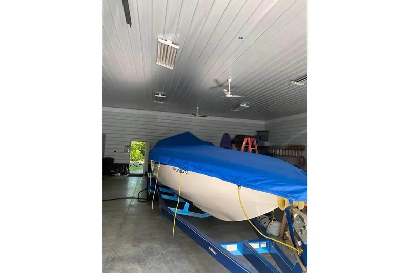 Slide: The Image of 2004 Sunsation 32 Dominator boat covered in blue tarp inside a garage. - 6