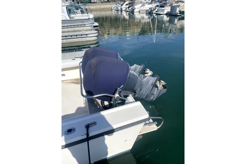 Slide: The Image of 2006 Parker 2520 SL Sport Cabin boat with dual outboard motors at a marina. - 18