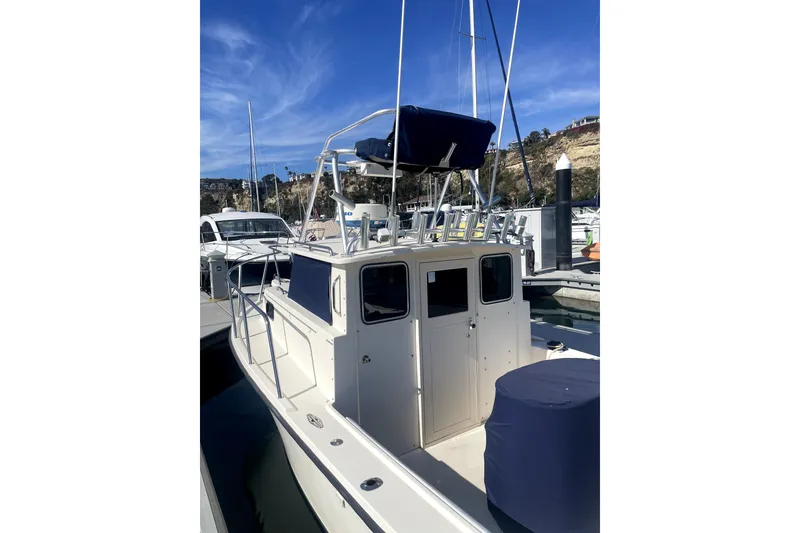 Slide: The Image of 2006 Parker 2520 SL Sport Cabin boat docked at marina under clear blue sky. - 19