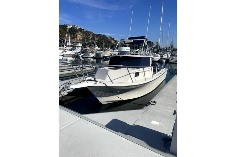 Slide: The Image of 2006 Parker 2520 SL Sport Cabin boat docked at marina under clear blue sky. - 20