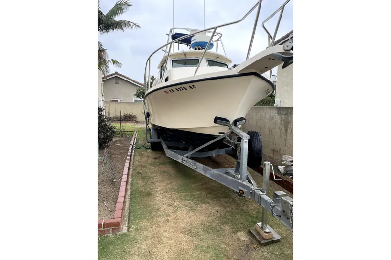 Slide: The Image of 2006 Parker 2520 SL Sport Cabin boat on trailer in residential yard. - 21