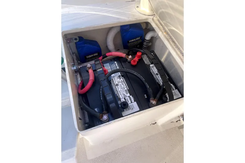 Slide: The Image of Battery compartment of a 2006 Parker 2520 SL Sport Cabin boat, featuring cables and Yamalube containers. - 25