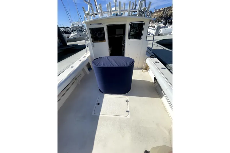 Slide: The Image of 2006 Parker 2520 SL Sport Cabin boat docked, featuring spacious deck and covered equipment. - 26