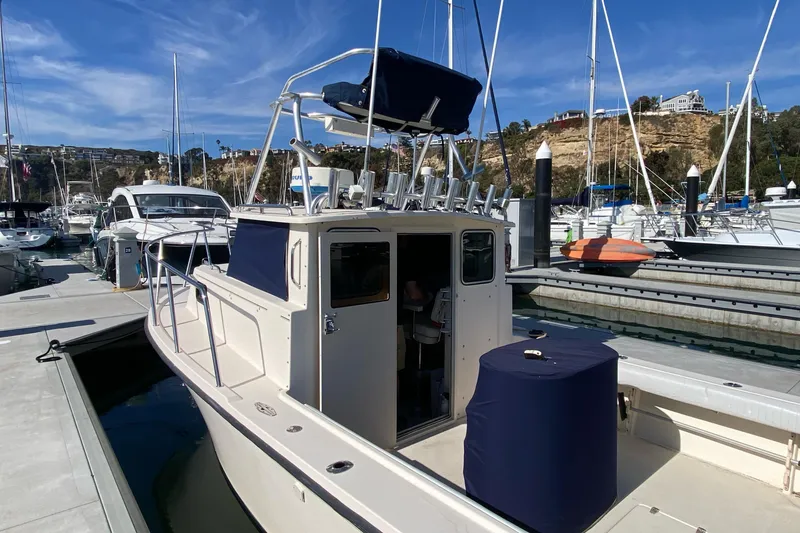 Slide: The Image of 2006 Parker 2520 SL Sport Cabin boat docked at marina under clear blue sky. - 4