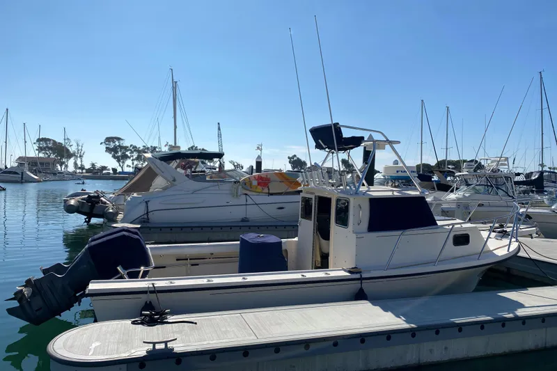 Slide: The Image of 2006 Parker 2520 SL Sport Cabin boat docked in a marina under clear blue skies. - 5