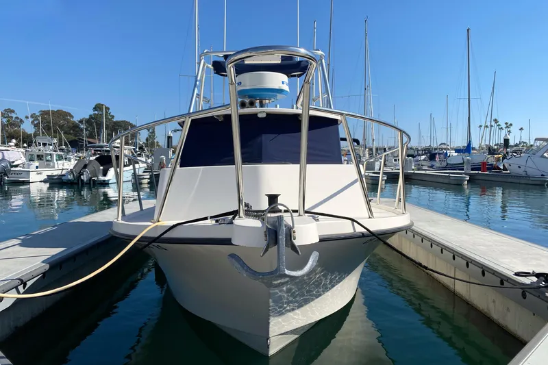 Slide: The Image of 2006 Parker 2520 SL Sport Cabin boat docked in a marina under clear blue skies. - 6