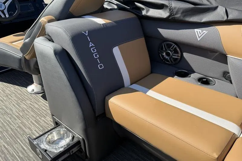 Slide: The Image of 2026 Viaggio x22u boat interior with tan and gray seating, cup holders, and speaker. - 13