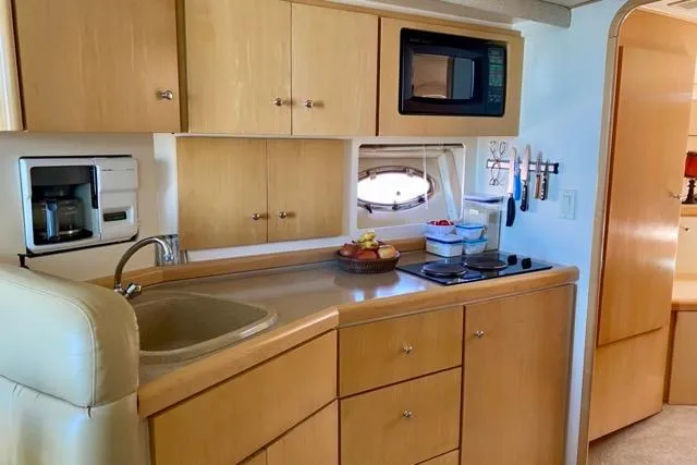 Slide: The Image of 1998 Carver 350 Mariner kitchen with microwave, sink, and wooden cabinets. - 10