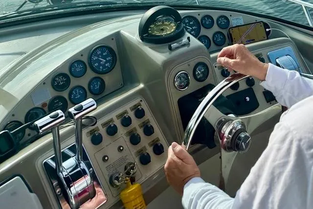 Slide: The Image of Helm of 1998 Carver 350 Mariner with gauges and controls, person steering. - 13
