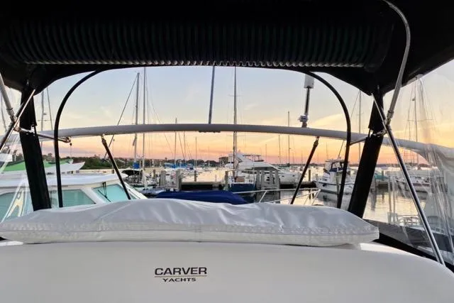 Slide: The Image of 1998 Carver 350 Mariner yacht at marina during sunset, showcasing elegant design and serene harbor view. - 17