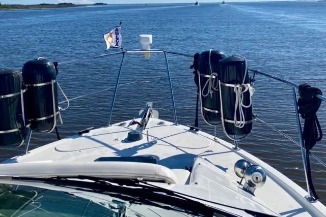 Slide: The Image of 1998 Carver 350 Mariner yacht cruising on open water, with clear blue skies. - 19