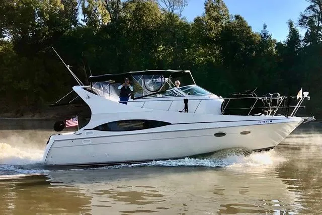 Slide: The Image of 1998 Carver 350 Mariner cruising on a calm river with lush green trees in the background. - 7