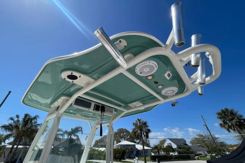 Slide: The Image of 2017 Everglades 243 Center Console boat with T-top and rod holders under clear blue sky. - 10