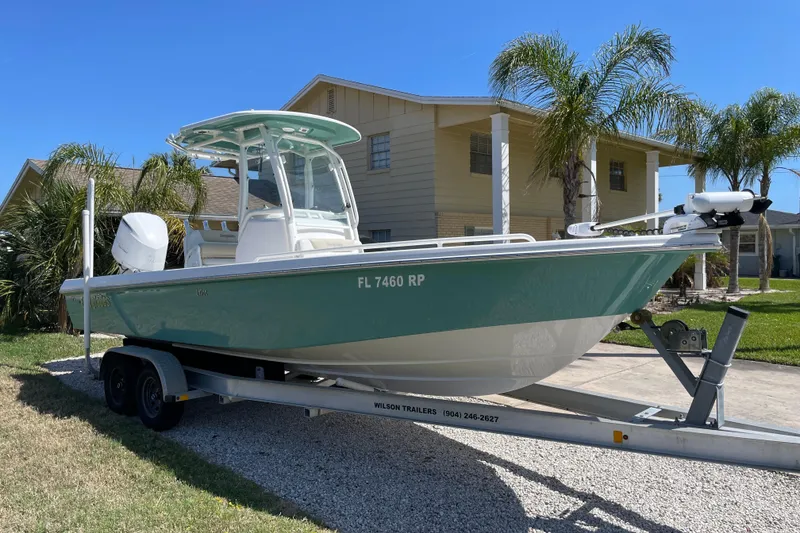 Slide: The Image of 2017 Everglades 243 Center Console boat on trailer, parked near palm trees and house. - 4