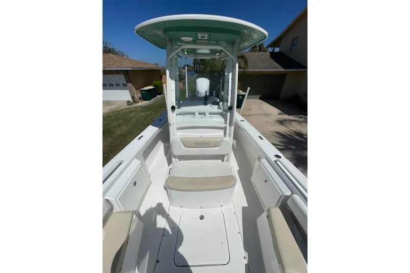 Slide: The Image of 2017 Everglades 243 Center Console boat with white seating and console, parked outdoors. - 8