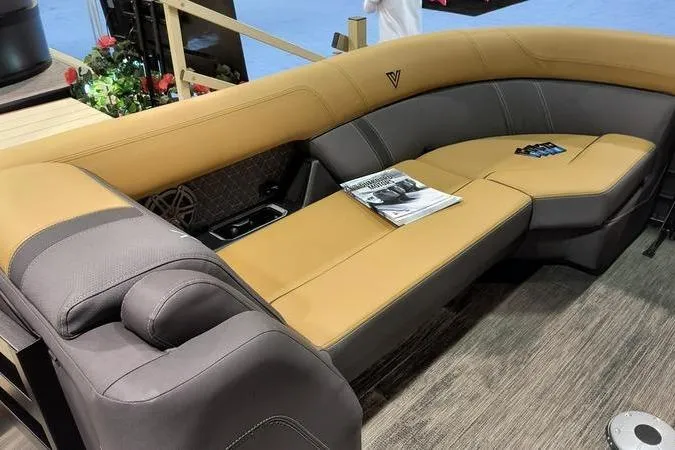 Slide: The Image of Luxurious Viaggio Z22U 2026 boat seating with tan and gray upholstery, featuring a magazine and remote controls. - 11