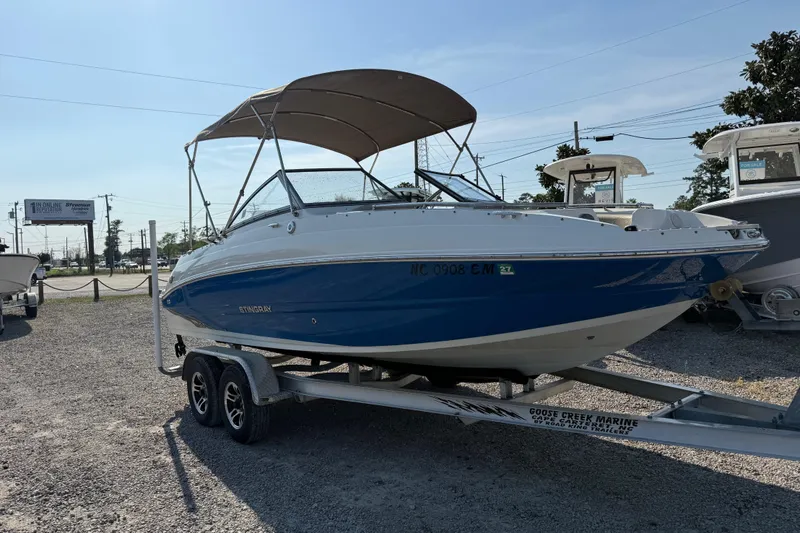 Slide: The Image of 2019 Stingray 201 DS boat on trailer with canopy in outdoor lot. - 11