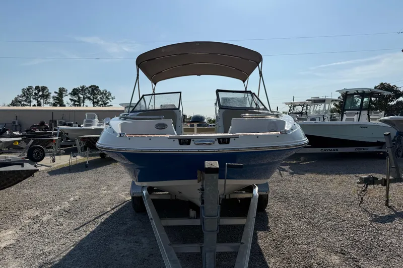 Slide: The Image of 2019 Stingray 201 DS boat on trailer, parked outdoors under clear sky. - 13
