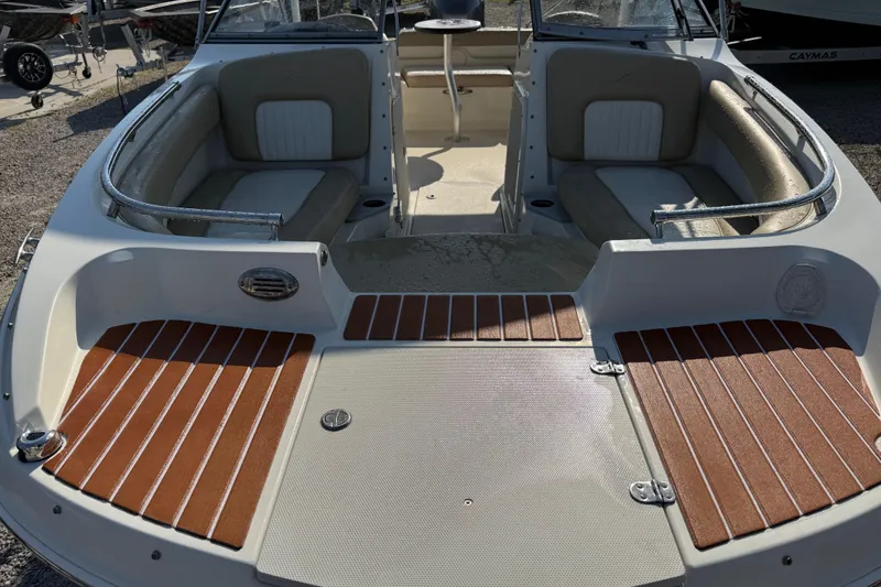 Slide: The Image of 2019 Stingray 201 DS boat interior with seating and wooden deck accents. - 14