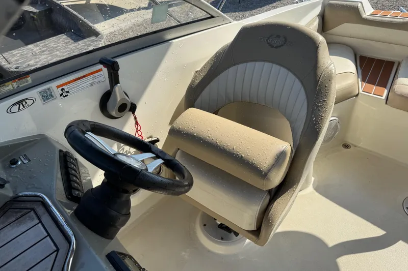 Slide: The Image of 2019 Stingray 201 DS boat interior with steering wheel and cushioned seat. - 22