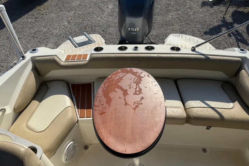 Slide: The Image of 2019 Stingray 201 DS boat interior with seating and table, featuring a 150 horsepower engine. - 23