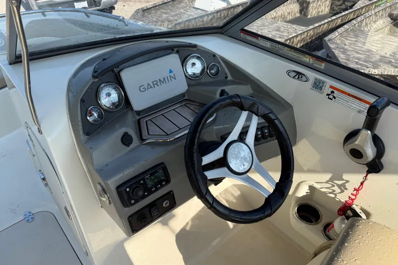 Slide: The Image of 2019 Stingray 201 DS boat dashboard with Garmin navigation system and steering wheel. - 24