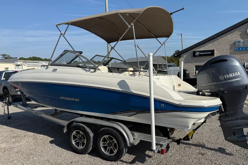 Slide: The Image of 2019 Stingray 201 DS boat with Yamaha motor on trailer, parked outdoors. - 3