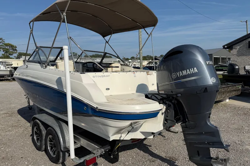 Slide: The Image of 2019 Stingray 201 DS boat with Yamaha 150 engine on trailer, parked outdoors. - 4