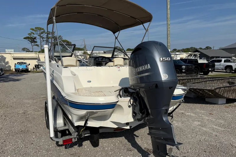 Slide: The Image of 2019 Stingray 201 DS boat with Yamaha 150 engine, parked outdoors. - 5