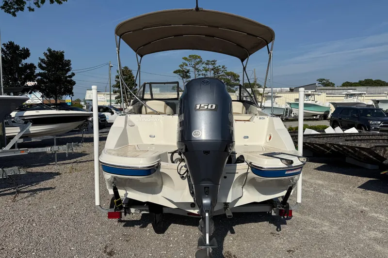 Slide: The Image of 2019 Stingray 201 DS boat with Yamaha 150 engine, parked outdoors. - 6
