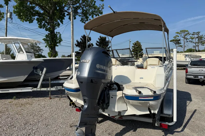 Slide: The Image of 2019 Stingray 201 DS boat with Yamaha 150 engine, parked outdoors. - 7