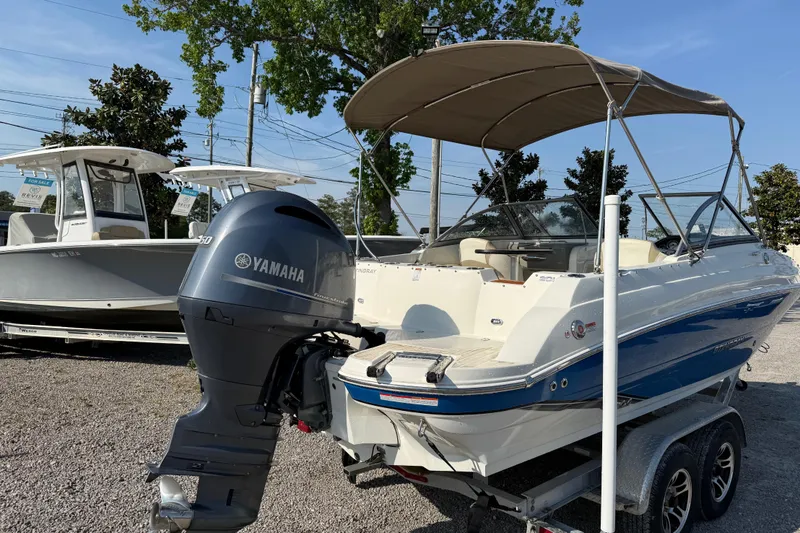 Slide: The Image of 2019 Stingray 201 DS boat with Yamaha outboard motor, parked on a trailer. - 8