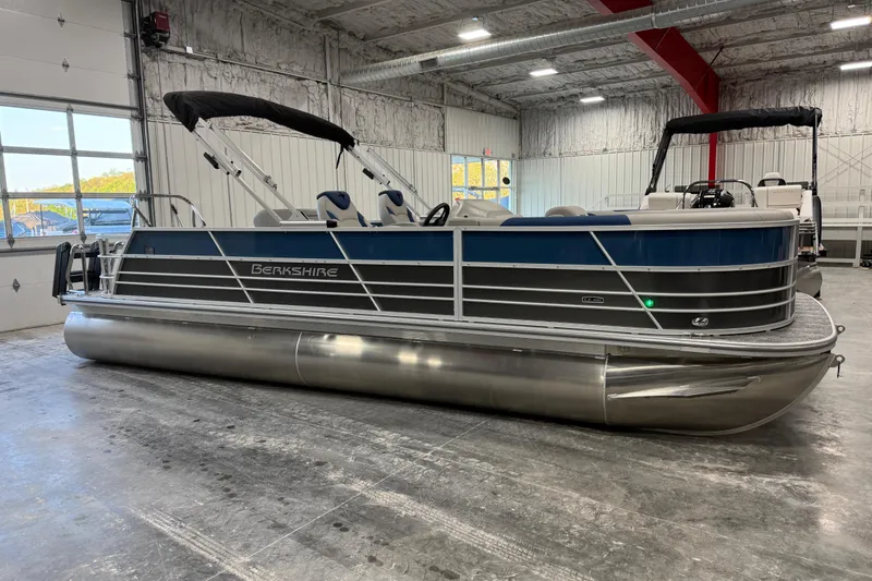 The Image of 2026 Berkshire 24 UL pontoon boat in a spacious indoor showroom. - 1