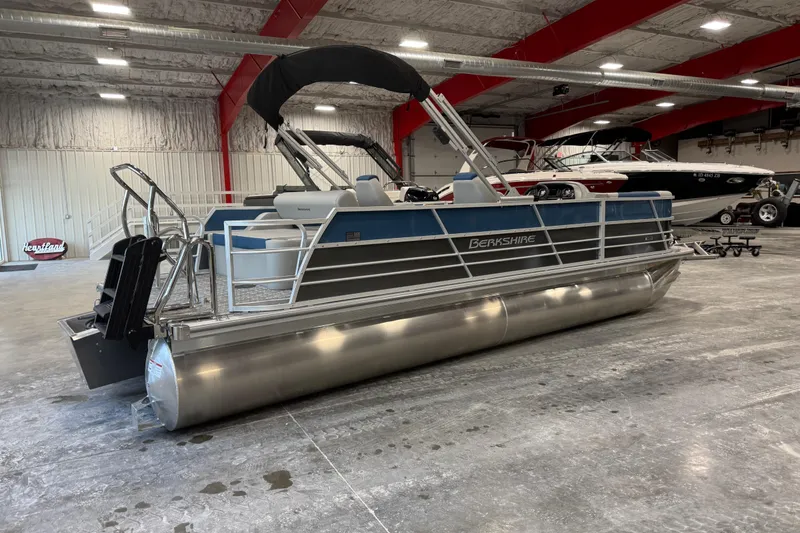 Slide: The Image of 2026 Berkshire 24 UL pontoon boat in a spacious indoor showroom. - 3