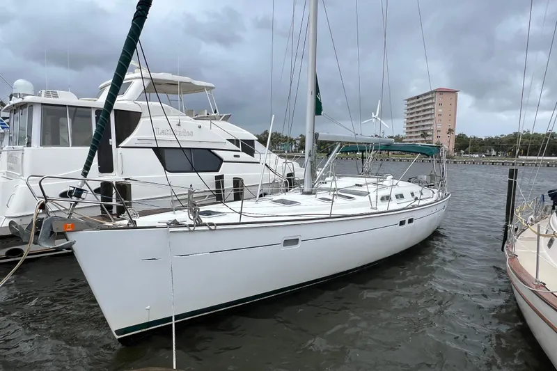 The Image of 2001 Beneteau 473 sailboat docked on a cloudy day, showcasing sleek design and spacious deck. - 0