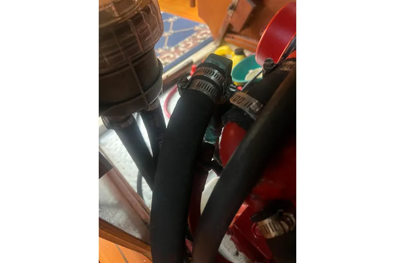 Slide: The Image of Engine compartment of a 2001 Beneteau Oceanis 473 sailboat, showing hoses and clamps. - 110