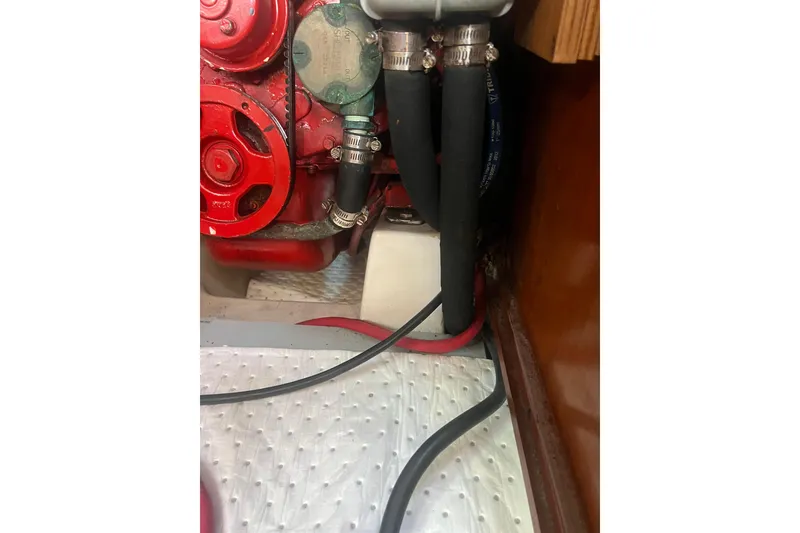Slide: The Image of Engine compartment of a 2001 Beneteau Oceanis 473 sailboat, featuring red engine components. - 113