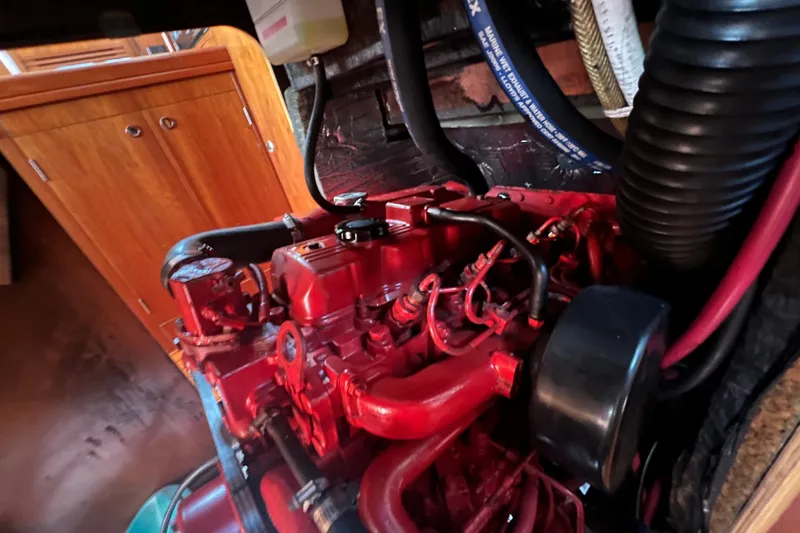 Slide: The Image of Engine compartment of a 2001 Beneteau Oceanis 473 sailboat, featuring a red engine. - 115